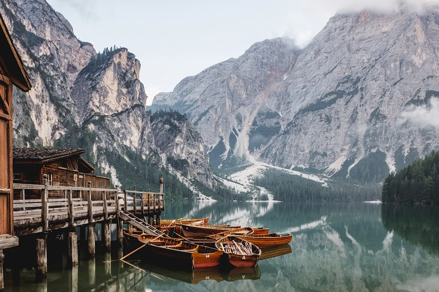 Wooden rowing boats moored on Lago di Braies beneath Dolomite peaks